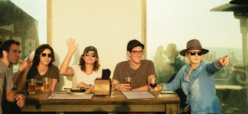 A group of friends sitting at an outdoor restaurant table in the daytime